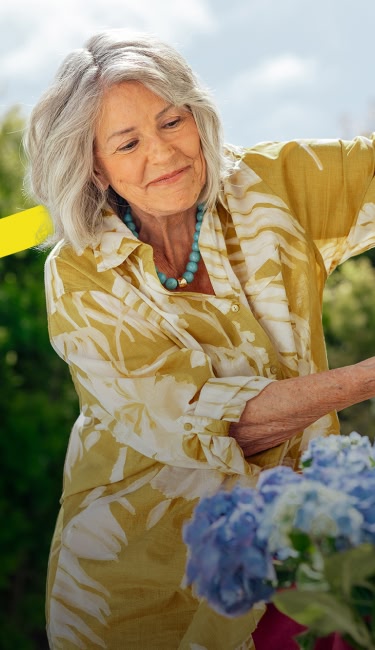 smiling woman watering flowers
